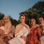 A group of women wearing traditional hijabs enjoying the outdoors at sunset.